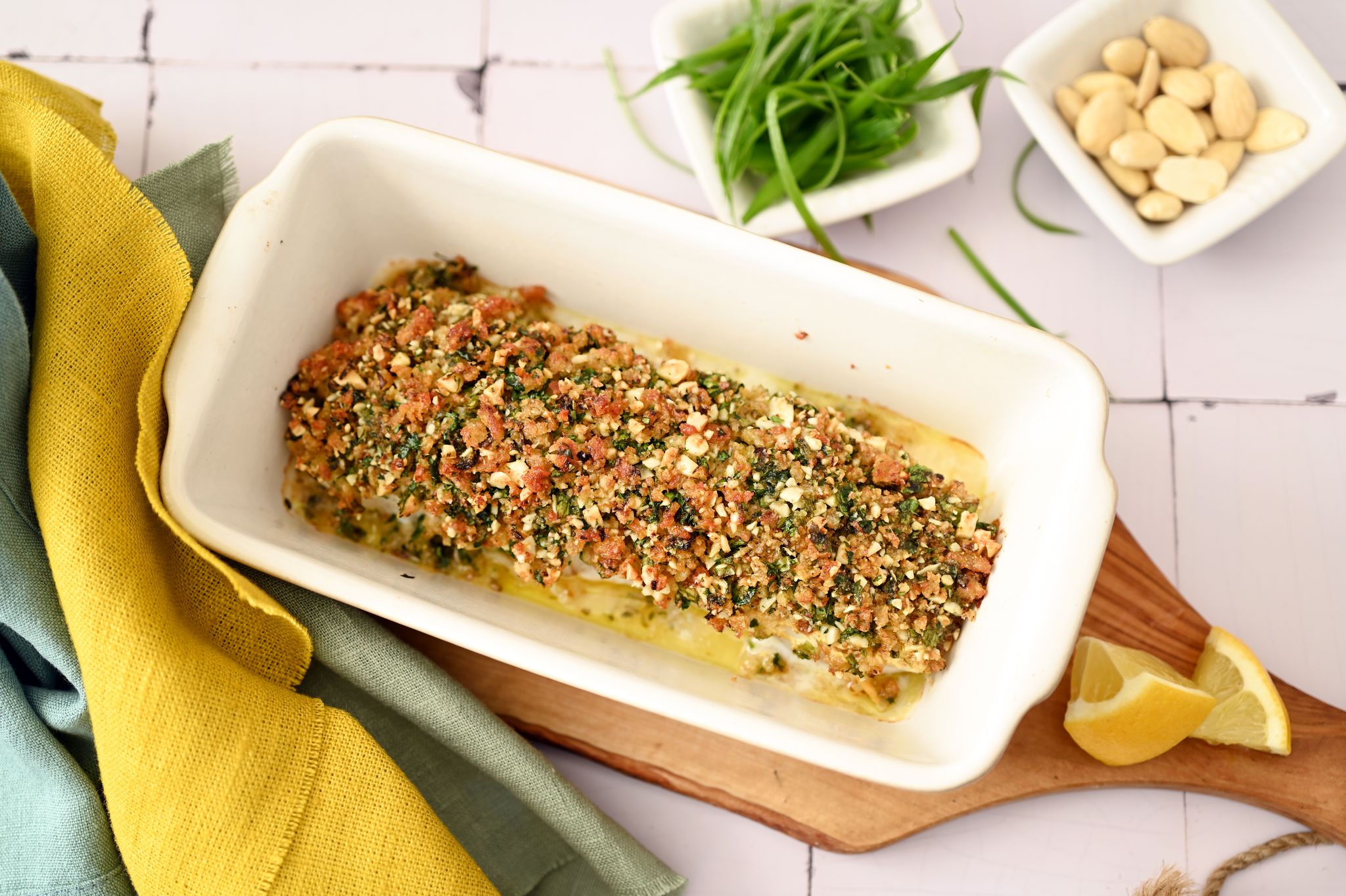 Der Crunch für diese Bärlauchkruste kommt von Mandeln und geröstetem Toast. Parmesan und Zitrone ergänzen die Würze des Bärlauchs.