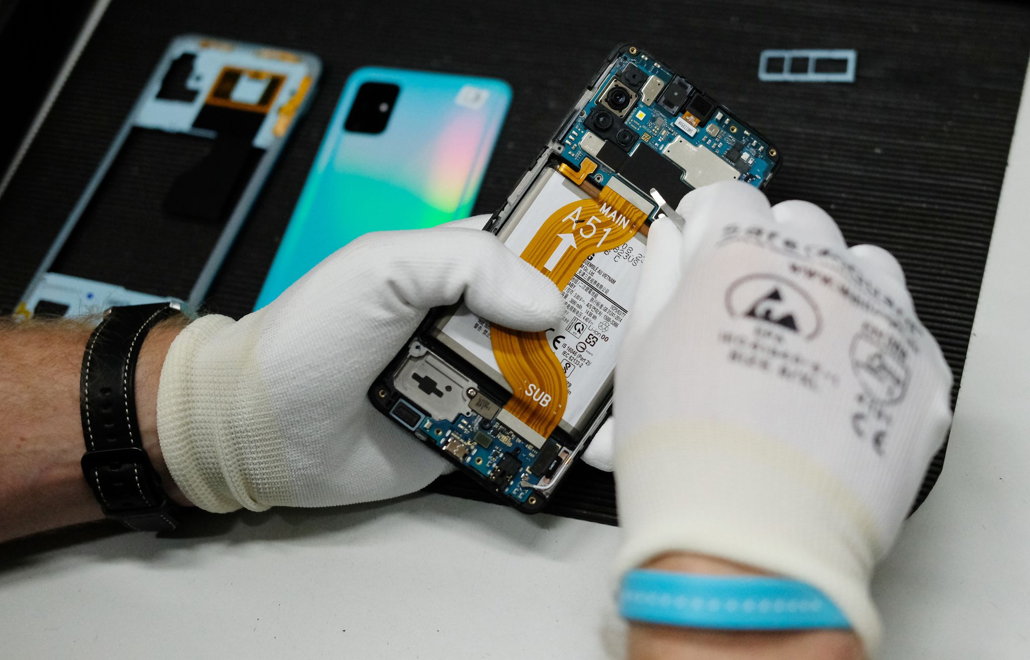 In einer Werkstatt wird ein altes Smartphone wiederaufbereitet.