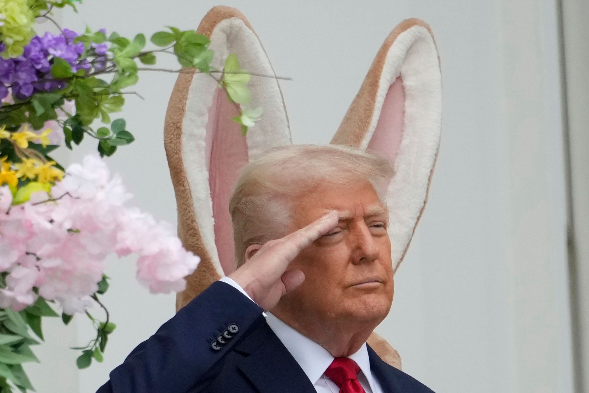 Donald Trump steht vor einem großen Osterhasen - und es sieht so aus, als hätte er sich die Ohren geliehen.
