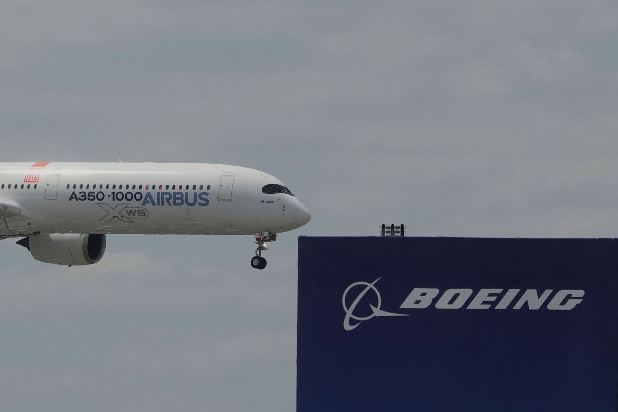 Die zwei großen Konkurrenten: Ein Airbus fliegt bei einer Vorführung auf der Luftfahrtmesse Salon du Bourget an einem Logo von Boeing vorbei.