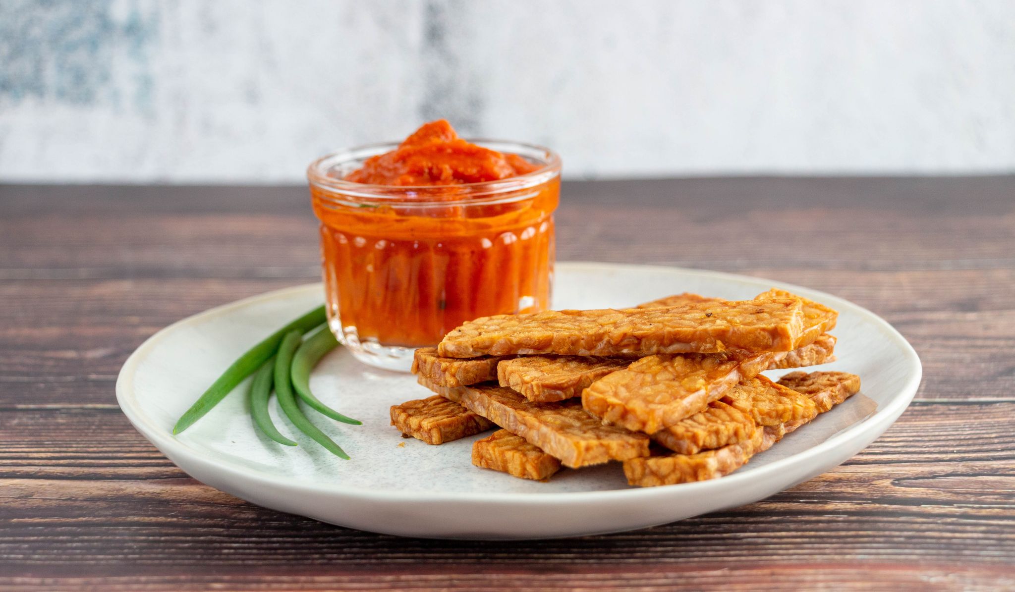 Durch Edelschimmel wachsen Sojabohnen zusammen und werden als Tempeh schnittfest. Es schmeckt würzig, lässt sich geschnitten knusprig braten oder frittieren und wie Chips essen.