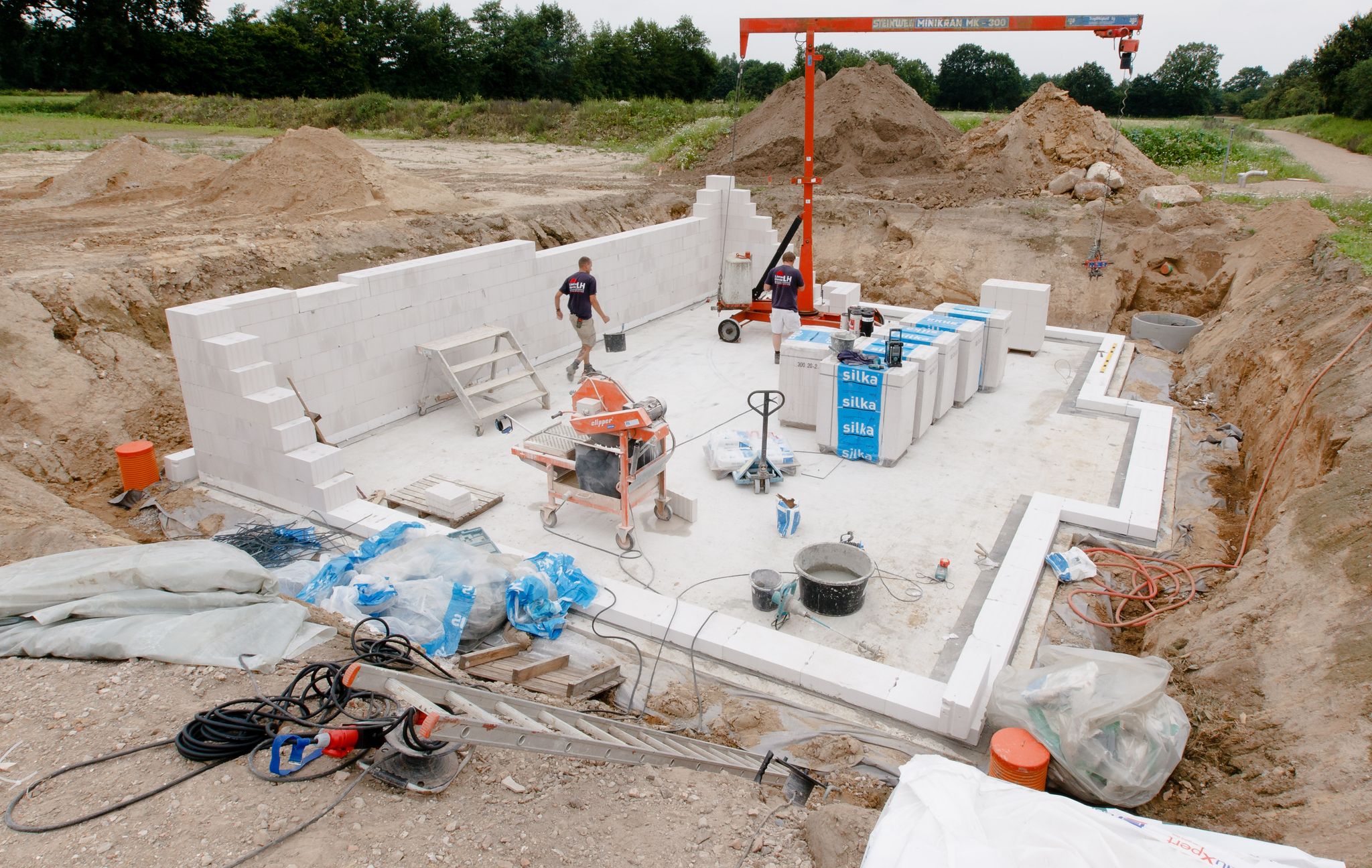 Vorausschauend planen: Bauherren sollten in der Baubeschreibung darauf achten, wie die Abwasserleitungen verlaufen sollen - damit die Bodenplatte später bei möglichen Reparaturen nicht wieder aufgerissen werden muss.