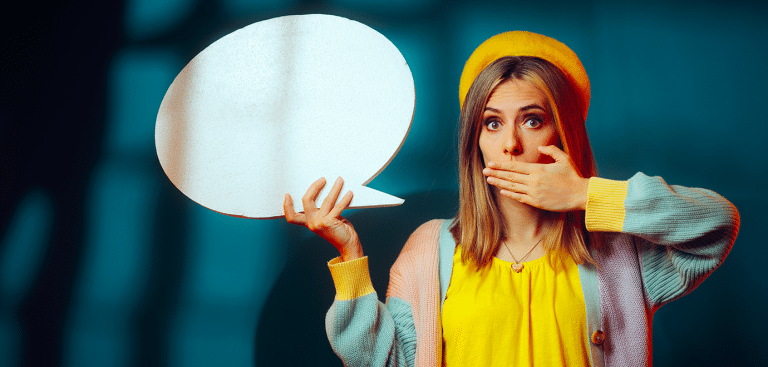 Foto: nicoletaionescu/iStock Frau hält sich Mund zu und eine Sprechblase in der Hand