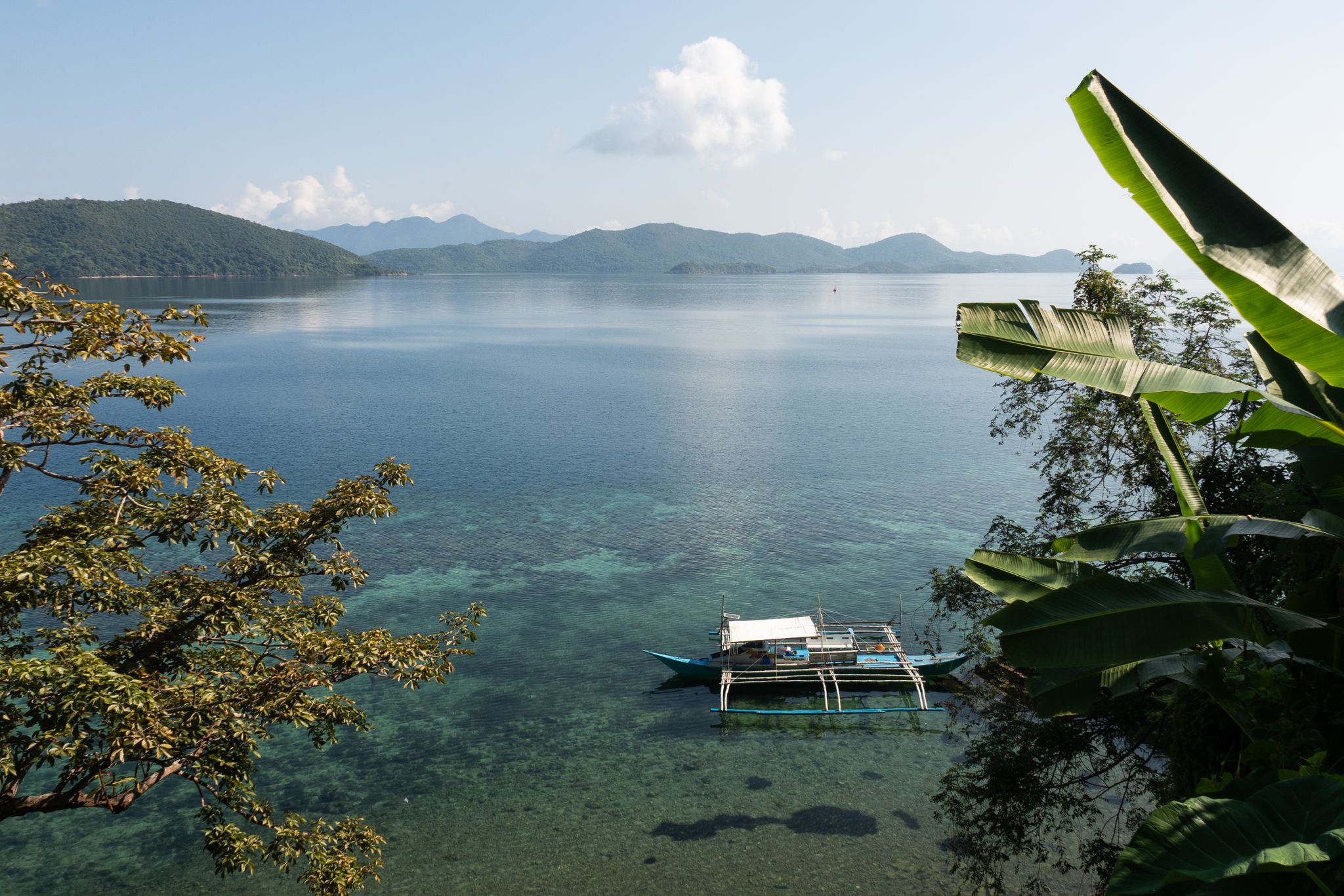 Im Wasser schaukelt ein Auslegerboot, eine Brise raschelt in den Palmblättern: So sieht ein verlorenes Inselparadies aus.