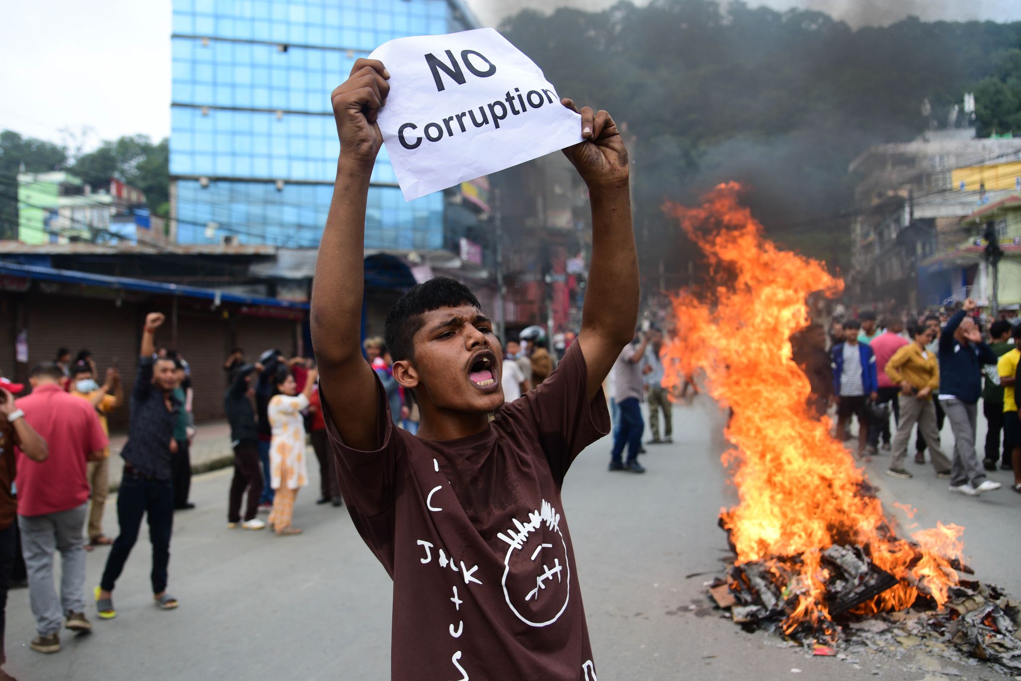 Ein Demonstrant in Nepal hält ein Blatt mit der Forderung nach einem Ende der Korruption hoch.