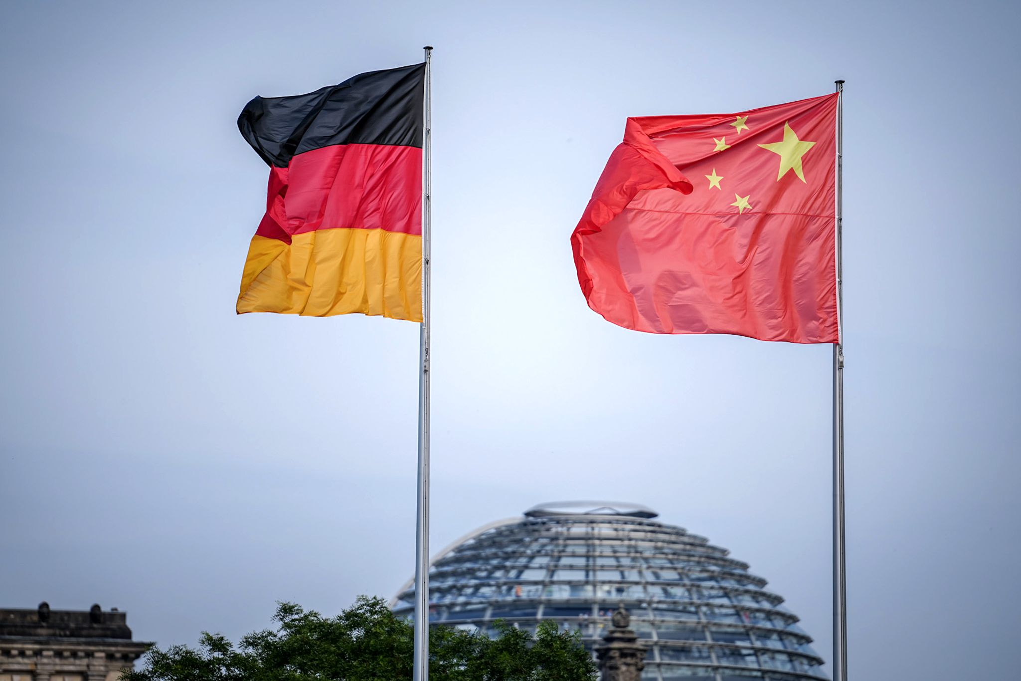 Die Flaggen von Deutschland und China wehen zum Auftakt des Deutschland-Besuchs der chinesischen Regierung vor dem Bundeskanzleramt, im Hintergrund die Kuppel des Reichstagsgebäudes.